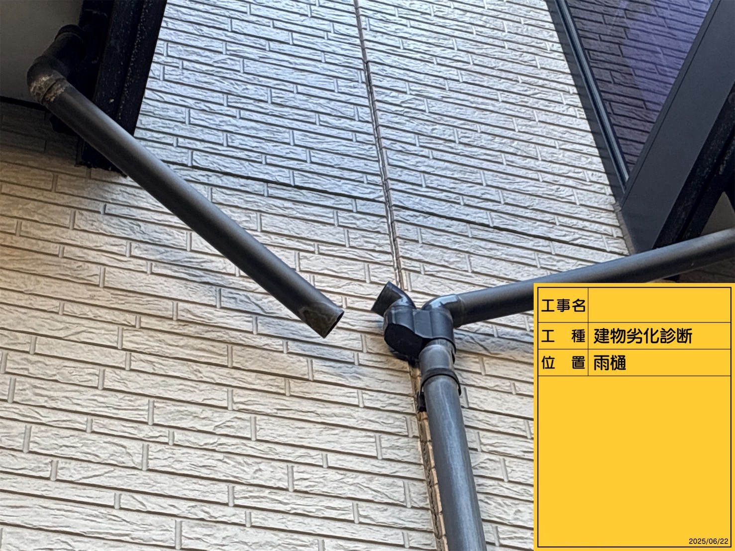 縦といが外れた白い外壁のアパート